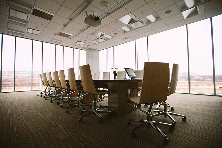 Salle de réunion avec de nombreuses chaises autour d'un table de conférence