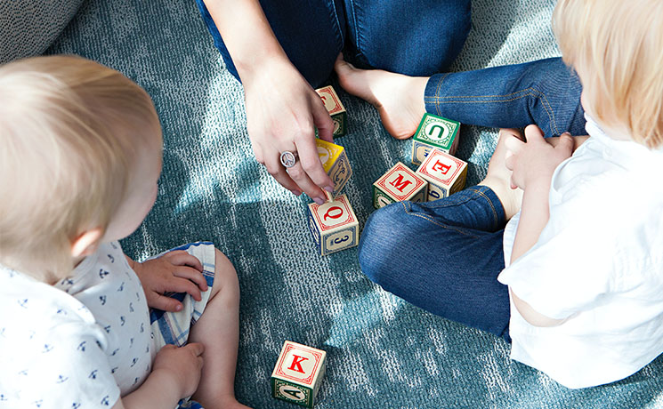 Deux enfants jouent aux cubes sur le sol