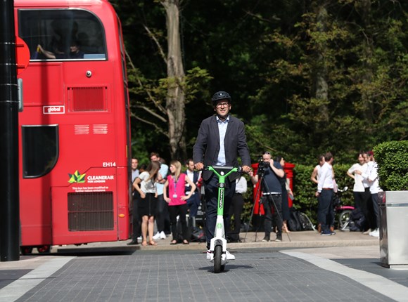 Un homme en trottinette dans une rue londonienne