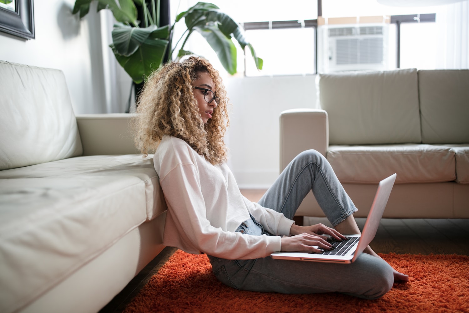 femme devant son ordinateur assise par terre