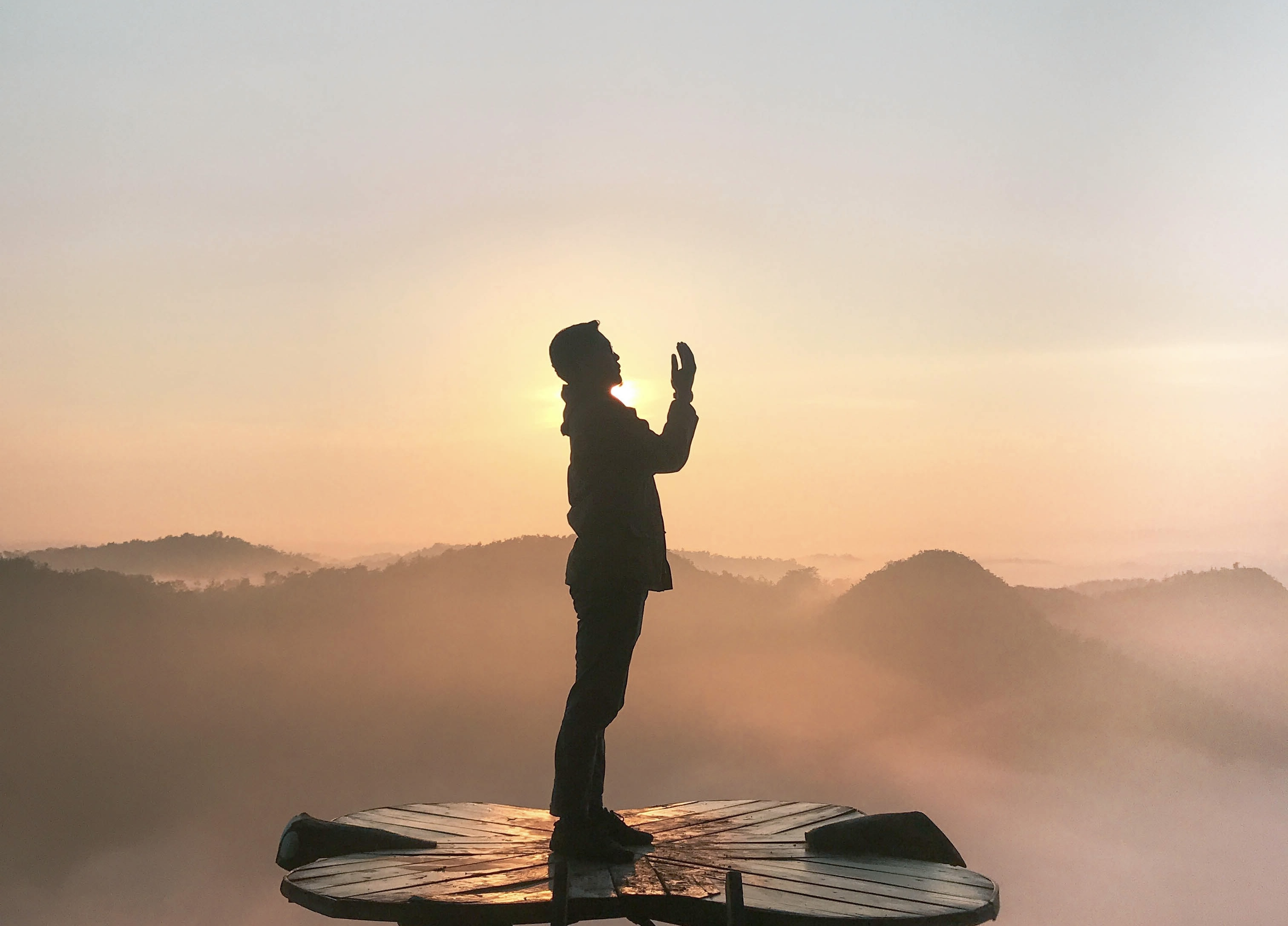 Un homme lève les mains au ciel