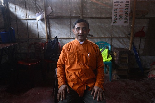 Le leader rohingya Mohib Ullah assis dans une pièce mal éclairée
