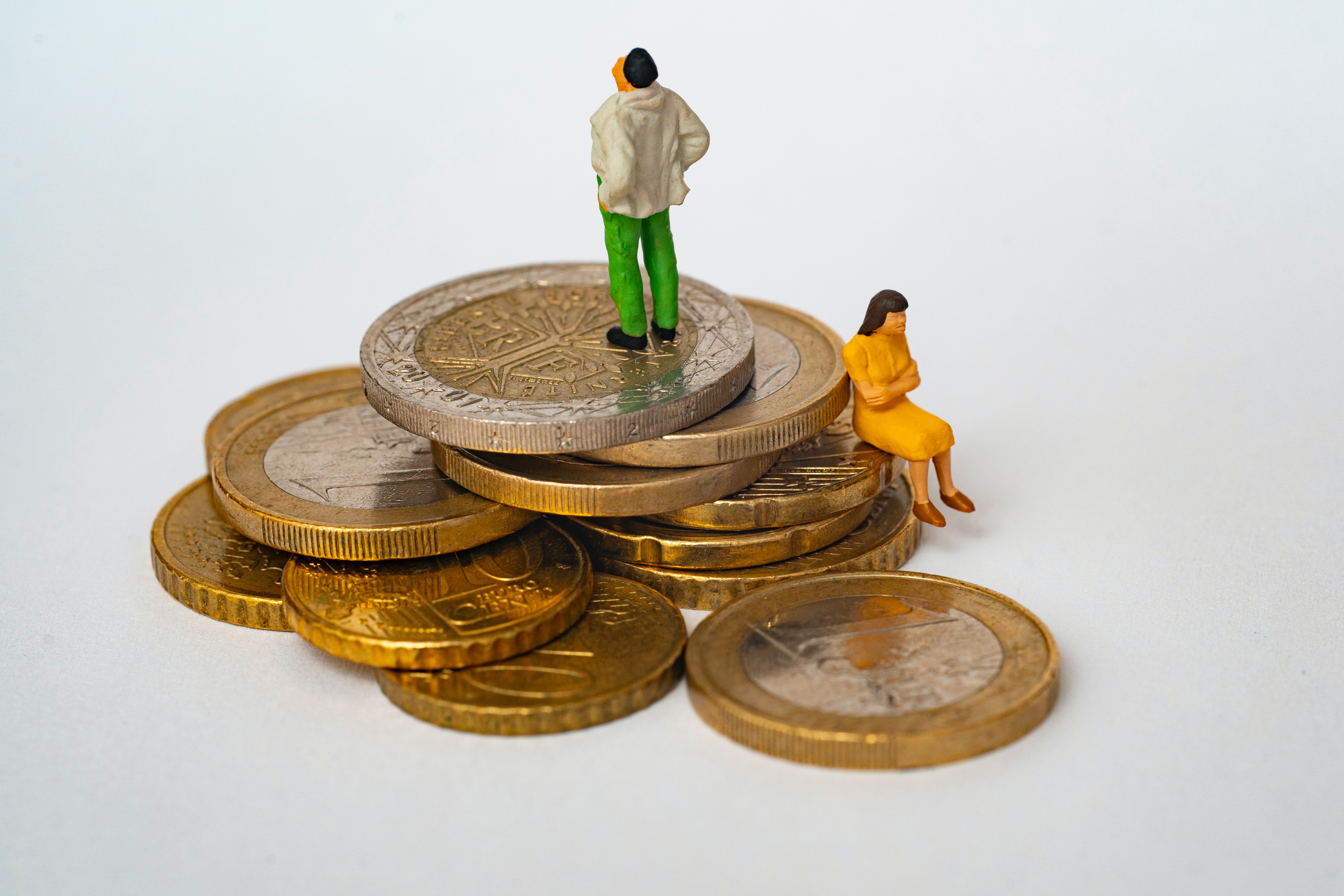 Bonhomme assis sur des pièces de monnaie