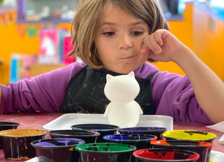 Fillette école maternelle avec des pots de peinture