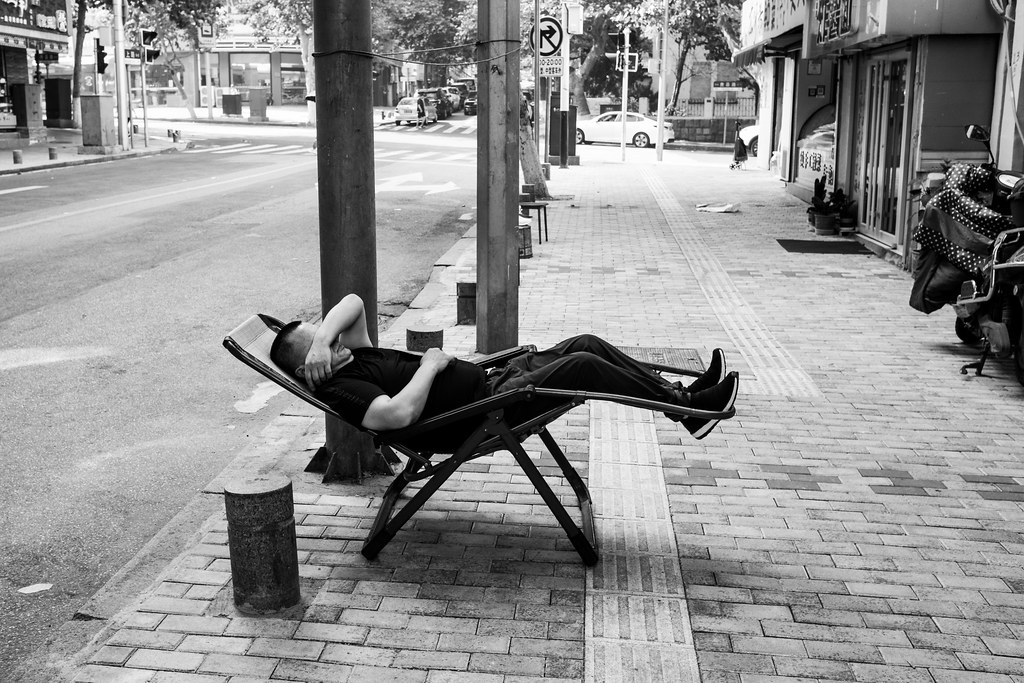Un homme fait la sieste dans la rue en Chine