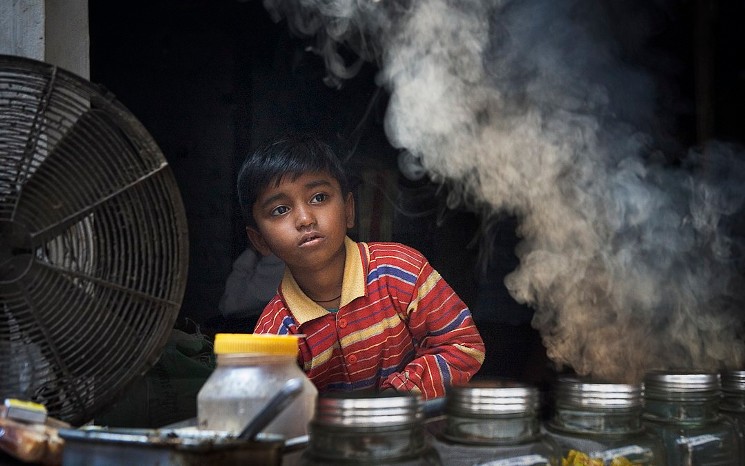 Un enfant tenant un stand dans la rue à Bénarès