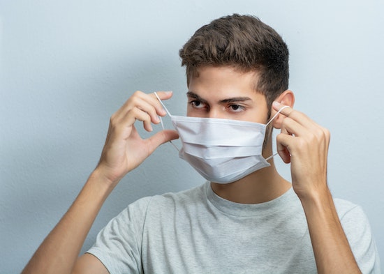 Un homme enlève son masque