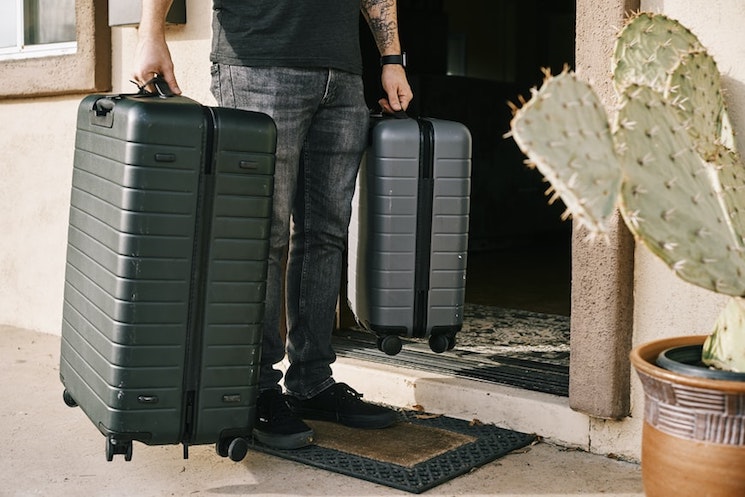 Homme avec valises à sa porte
