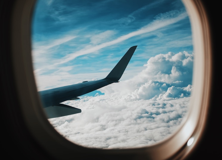 aile d'un avion dans les airs à travers le hublot
