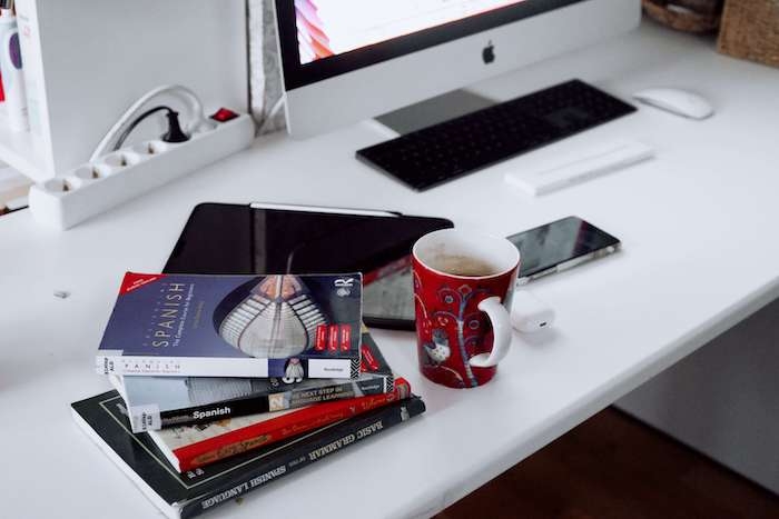 des méthodes d'espagnol sur un bureau avec un ordinaeur mac à Valencia