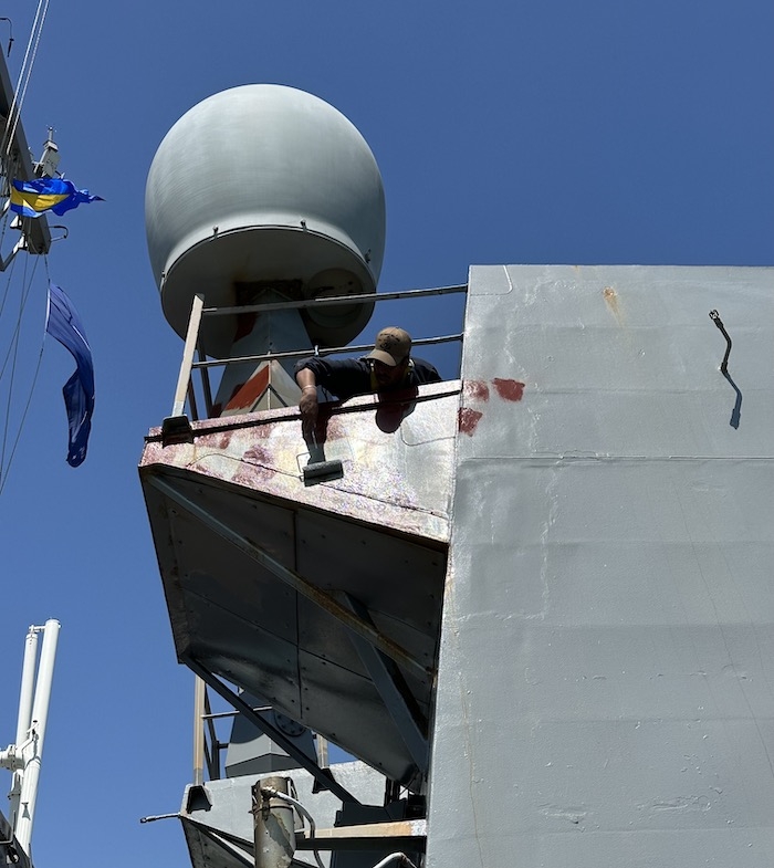 un soldat en train de peindre à bord du bateau