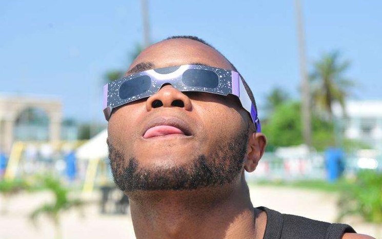 Homme portant des lunettes adaptées à l'observation des éclipses solaires
