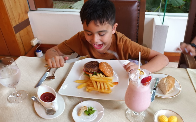 Un enfant devant un hamburger au restaurant Le Crystal Chiang Mai