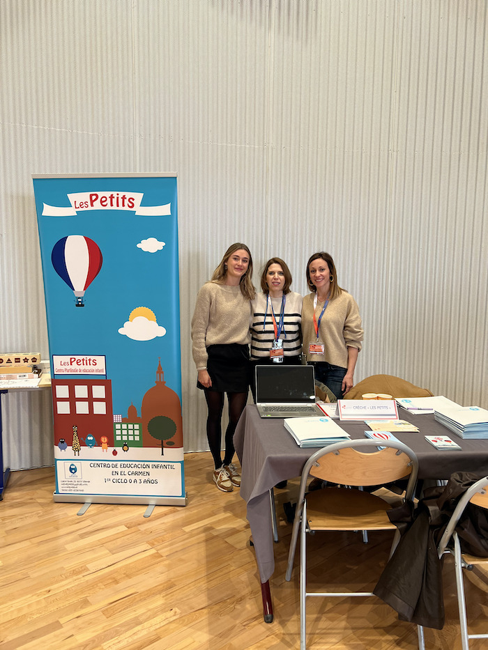 Trois femmes posant devant le stand Les Petits lors des Portes Ouvertes du lycée français de Valence