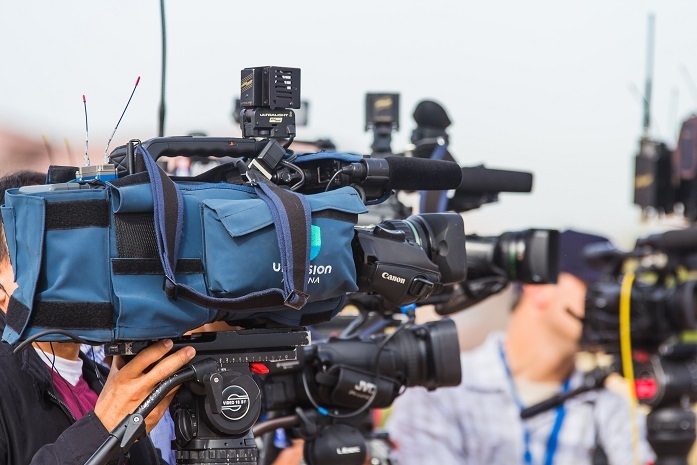 un journaliste de la television film avec sa camera